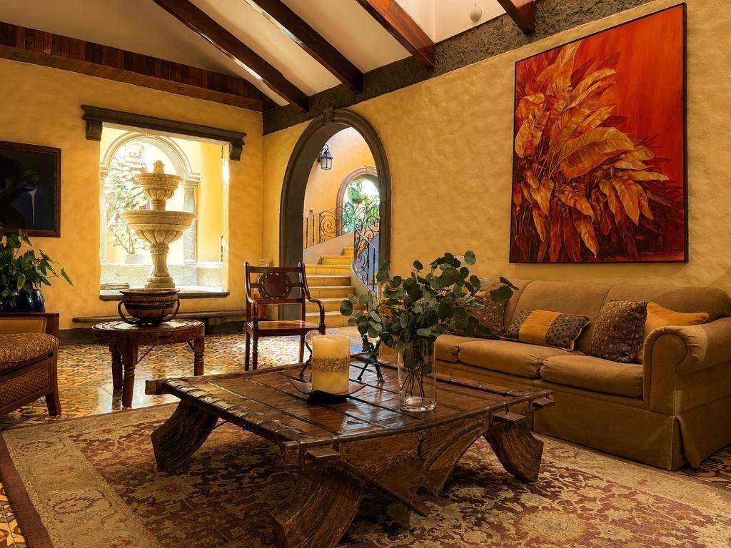 Sala de estar con fuente de piedra, vigas de madera y arcos