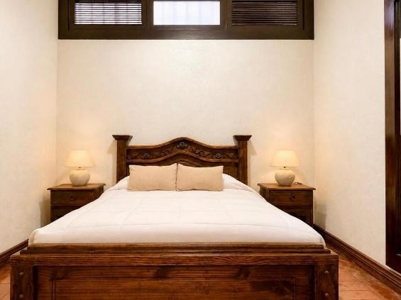 Habitación con cama de madera tallada y lámparas de noche