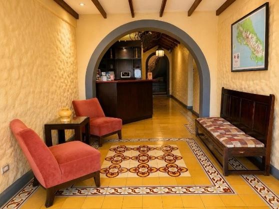 Recepción con arco, banca de madera y mosaico en el piso