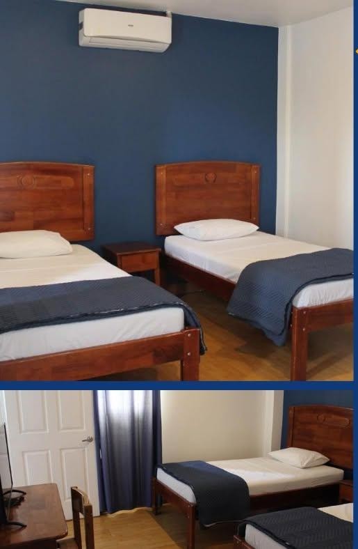 Habitación con dos camas individuales y aire acondicionado